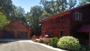 A two-story log cabin with a garage, surrounded by trees and a well-maintained lawn. - Root River Valley Cabin ~ Lanesboro, MN (Lanesboro)