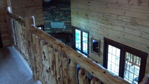 A wooden interior with a staircase, stone wall, and windows. - Root River Valley Cabin ~ Lanesboro, MN (Lanesboro)