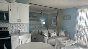 Ein modernes Wohnzimmer mit Essbereich, Küche und Blick auf den Strand.