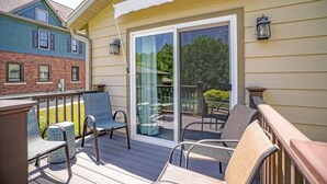 A covered deck with outdoor furniture and a sliding glass door leading to a patio. - A Pleasant Retreat (Sun Prairie)