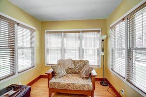 Relax in this inviting room with a sofa against a wall of large windows and a floor lamp for extra light.