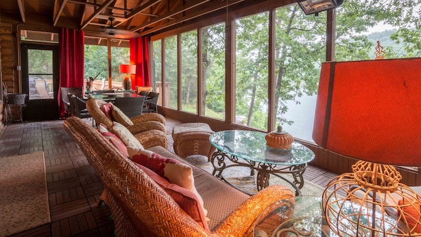 Una habitación acogedora con sofás de mimbre, una mesa de vidrio y vistas al exterior.