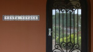 Una reja negra de hierro forjado con un letrero encima que dice "VISTA VIVACE".