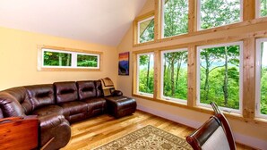 A room with a large sectional sofa, multiple windows, a wooden ceiling, and a rug. - Sweet Refrain in Pisgah Forest with VIEW (PIsgah Forest)