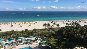 A beach resort with a pool area, palm trees, and a view of the ocean. - Between Lowe's and Ritz Carlton Hotels Beachfront on Lincoln (Miami)