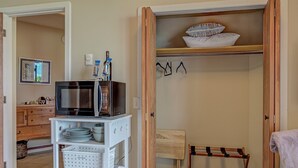 A compact kitchen with a microwave, a small fridge, and a white storage unit with dishes. - Private Guest Suite, "Hilltops II" (Salmon)
