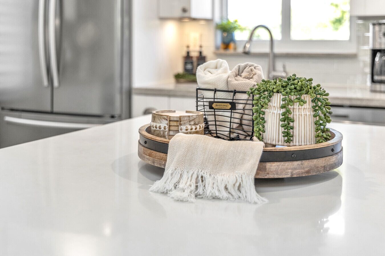 Un îlot de cuisine avec un plan de travail blanc, un set de table en fibres naturelles, une petite plante et une serviette blanche.