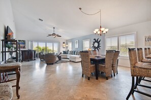 Relax in this inviting living area with a high ceiling, dining table, and comfortable sofa set.