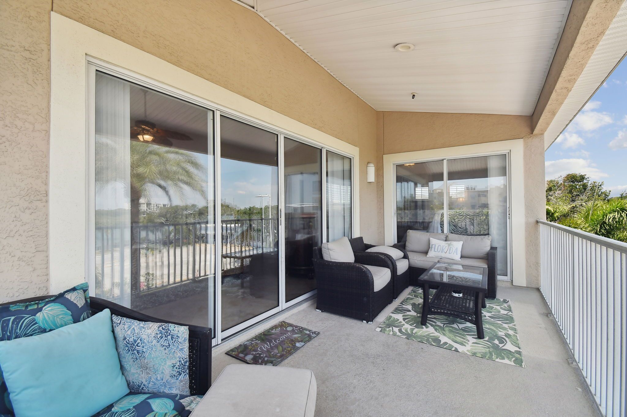 A balcony with a sofa, a coffee table, and a rug.