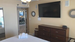 Hotelkamer met een bed, een dressoir, een plafondventilator, een televisie en uitzicht op de eetruimte.