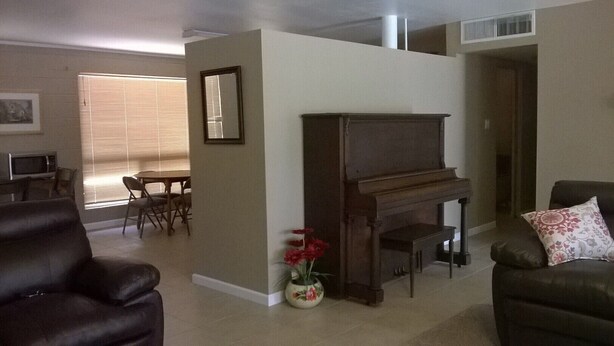 A living room with a fireplace, a piano, a dining area with a table and chairs, and a sofa. -  Sleeps 12 ; within walking distance to shops; boat parking 9ft x 30ft  NO tower (Page)
