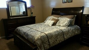 A bedroom with a large bed, a dresser, a mirror, and a lamp. -  Sleeps 12 ; within walking distance to shops; boat parking 9ft x 30ft  NO tower (Page)