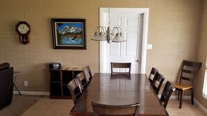 A dining room with a long wooden table, six chairs, a chandelier, a clock, and a painting on the wall. -  Sleeps 12 ; within walking distance to shops; boat parking 9ft x 30ft  NO tower (Page)