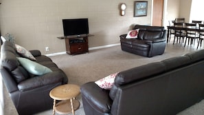 Relax in this cozy living space with a comfortable sofa, flat-screen TV, and dining area.