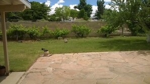 A stone patio with a grassy yard and a wooden fence. -  Sleeps 12 ; within walking distance to shops; boat parking 9ft x 30ft  NO tower (Page)