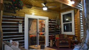 A cozy log cabin interior with a sofa, armchair, and a table. - Relaxing, spacious cabin w/ hot tub and Starlink's high-speed internet service (Darby)