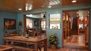 A spacious dining area with wooden furniture, a large table, and a potted plant. - Relaxing, spacious cabin w/ hot tub and Starlink's high-speed internet service (Darby)