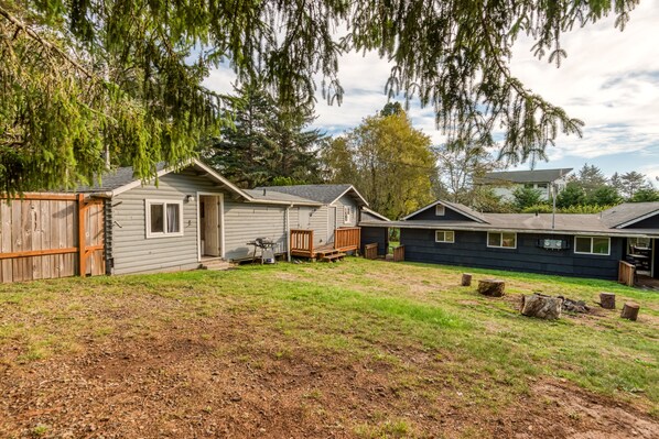 A row of cabins with a grassy yard and wooden fences. - Surf Haven Unit A w/fire pit walking distance to surfing beaches (Otter Rock)