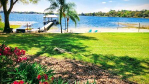 A lakeside view with a gazebo, lounge chairs, and a dock.