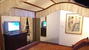A bedroom with a bed, a television, a dresser, and a painting on the wall. - Cottage on Historic Gentleman's Farm (Chester Springs)