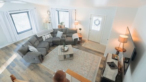 Een moderne woonkamer met een modulaire bank, een salontafel en een televisie.