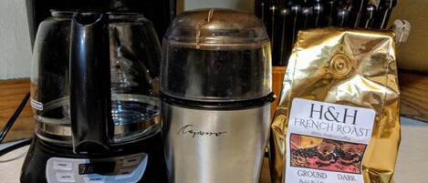 Una cafetera, un termo y una bolsa de café tostado francés H&H sobre una encimera de cocina.