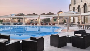Zona junto a la piscina con mobiliario exterior y una piscina grande.
