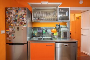 Eine kleine Küche mit Kühlschrank, Geschirrspüler und Spüle.