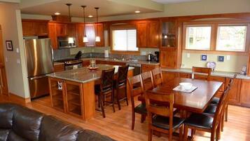 A modern kitchen with wooden cabinets, stainless steel appliances, and a central island with seating.