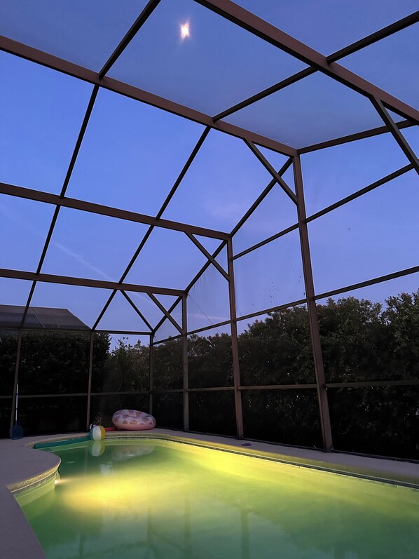 An indoor swimming pool with a clear view of the sky through a metal roof structure. - 4 Bedroom 3 bathroom Executive Villa. Gorgeous view from the pool deck. (Davenport)