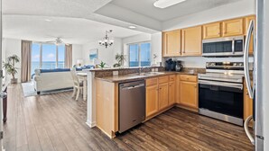 A modern kitchen with wooden cabinets, stainless steel appliances, and a dishwasher. - Oceanfront End Unit 4BR 3BA Sleeps 12 75 Inch TV Crescent Shores N Myrtle Beach (North Myrtle Beach)