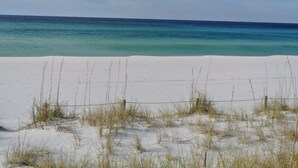 Une plage de sable blanc bordée d’une eau d’un bleu cristallin.
