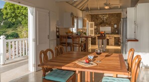 Un comedor con una mesa de madera, sillas y vistas al exterior.