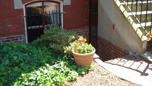 Un bâtiment en briques avec une fenêtre, un pot de fleurs et un escalier.