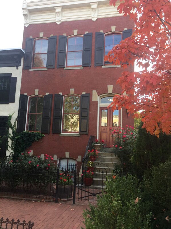 A red brick building with black shutters, a number '415' on the door, and a small garden with red flowers. - NESTLED IN PRIME CAPITOL HILL LOCATION - STEPS AWAY TO EVERYTHING! (Washington)