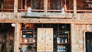 A rustic wooden interior with a high ceiling, exposed beams, and a central wooden table with chairs. - Book for fall and winter now… dates are filling up!! (Maple)