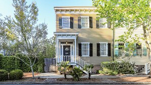 A two-story house with a front porch, a brick entrance, and a number '516' on the door. - Jingle Bells Square House (Savannah)