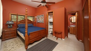 Cozy bedroom with a four-poster bed, nightstand, and dresser, featuring a closet and vanity.