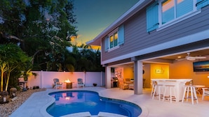 A modern house with a swimming pool, outdoor seating, and a patio area.