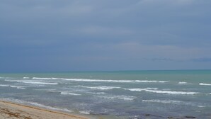 Ein Strand mit Wellen und blauem Himmel.