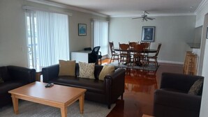 A living room with a sofa, coffee table, and dining table.
