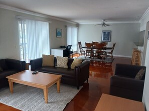 A living room with a sofa, coffee table, and dining table.