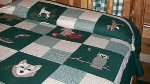 Een rustiek houten bed met een sprei met dierenprint.