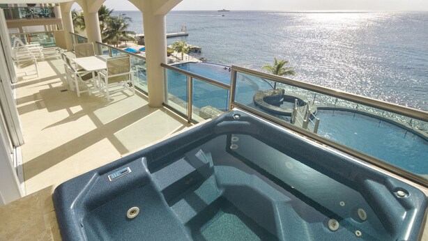 A balcony with a hot tub, pool, and ocean view. - Luxurious Oceanview Condo in Cozumel (Cozumel, Centre)