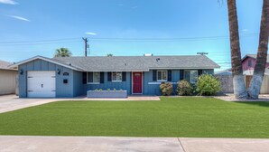 A single-story house with a red door, a garage, and a well-maintained lawn. - PRIVATE POOL - NEW EVERYTHING! Be our guest! (Scottsdale)