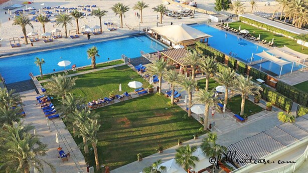 A resort with a large swimming pool, sun loungers, palm trees, and a beach area. - * Stunning! 5*- 4 BR-Oceanfront-Apartment-Private Beach- Ocean Views*  (Dubai)