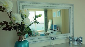 A bathroom with a large mirror, a vase with flowers, a clock, and a decorative item on the counter. - * Stunning! 5*- 4 BR-Oceanfront-Apartment-Private Beach- Ocean Views*  (Dubai)