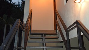 Eine Wendeltreppe mit Holzbeschlägen und Metallgeländern führt zu einem modernen Gebäudeeingang.