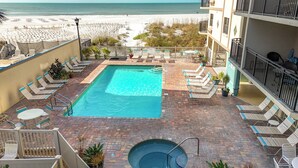 A rooftop pool with lounge chairs and a view of the beach.