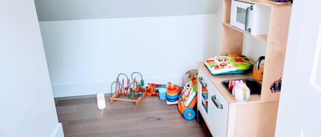 A child's play area with toys and a wooden cabinet.